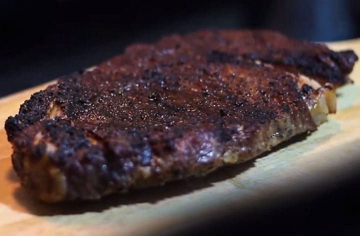 a piece of steak sitting on top of a wooden cutting board