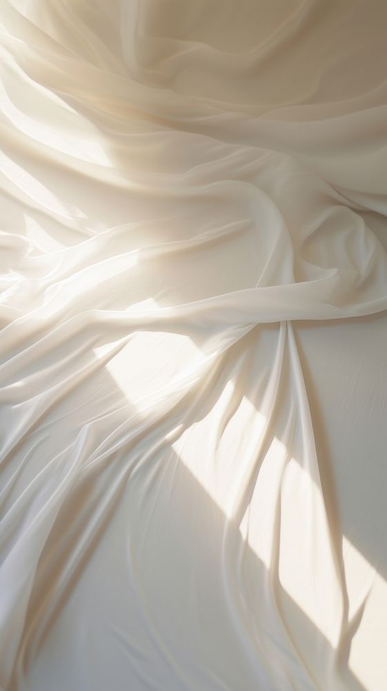 the white fabric is flowing in the wind on the bed sheet, with sunlight streaming through it