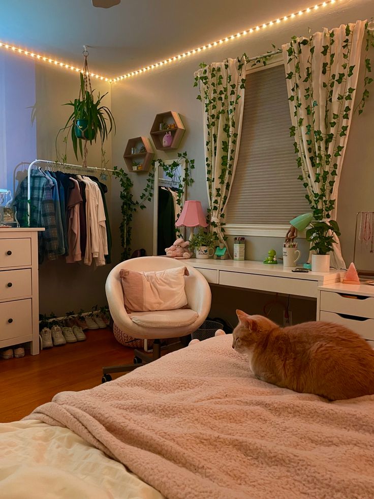 an orange cat laying on top of a bed next to a white dresser and chair