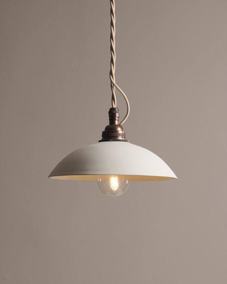 a white light hanging from a ceiling fixture with two lights on each side and a rope in the middle