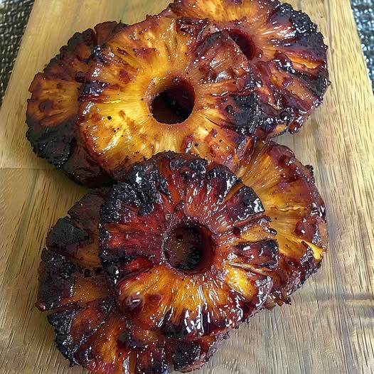 two pieces of pineapple sitting on top of a wooden cutting board