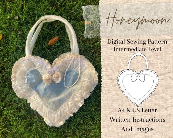 a heart shaped bag sitting on top of a green grass covered ground next to an information card