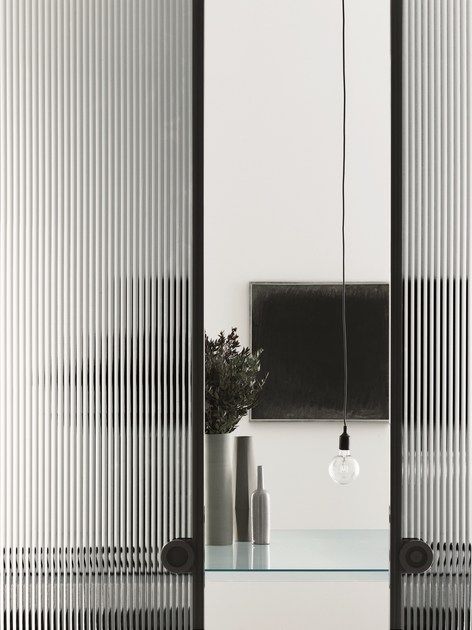 a mirror and some vases on a table in front of a wall with vertical blinds