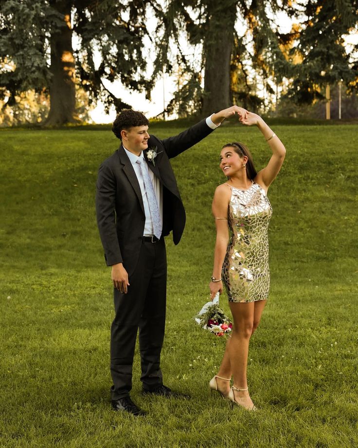 a man and woman are standing in the grass