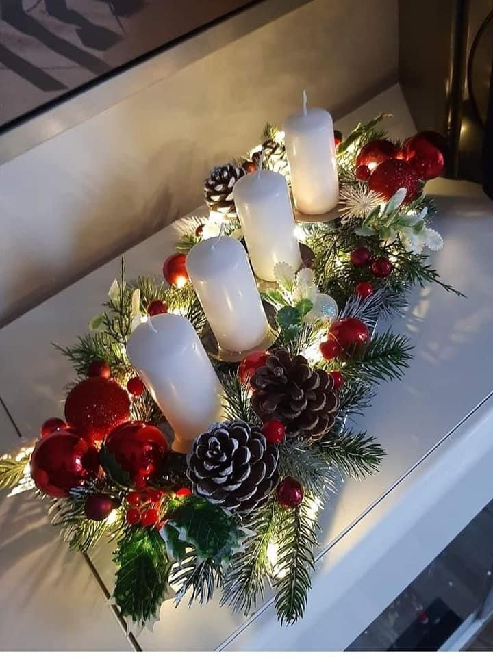 christmas decorations with candles and pine cones on a table