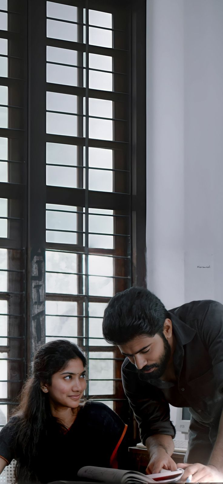 a man and woman looking at something on a table