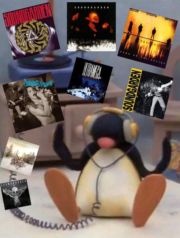 there is a stuffed penguin that has been placed in front of some records and cds