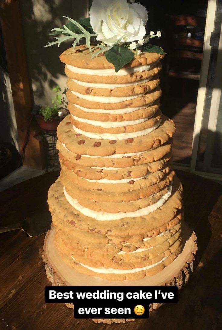 a wedding cake made out of cookies and white flowers on the top is featured in an ad for best wedding cake i've ever seen