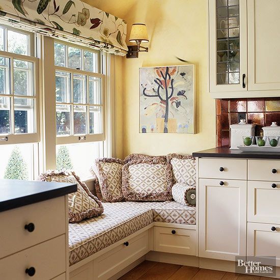 a kitchen with white cabinets and window seats