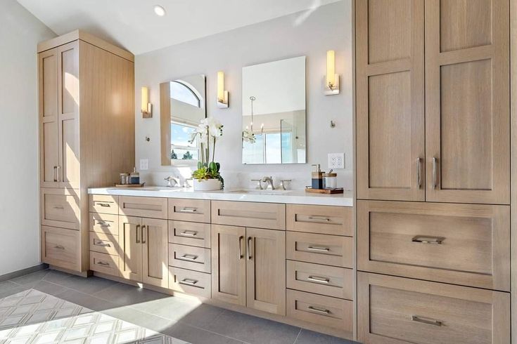 a large bathroom with two sinks and wooden cabinets