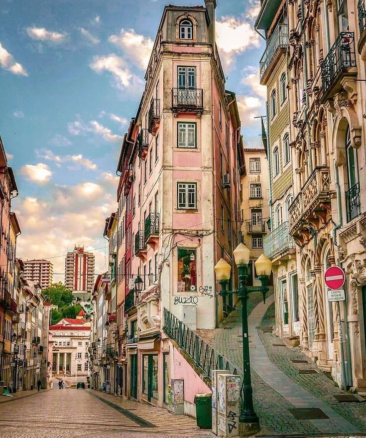 an old city street lined with tall buildings and cobblestone streets on both sides