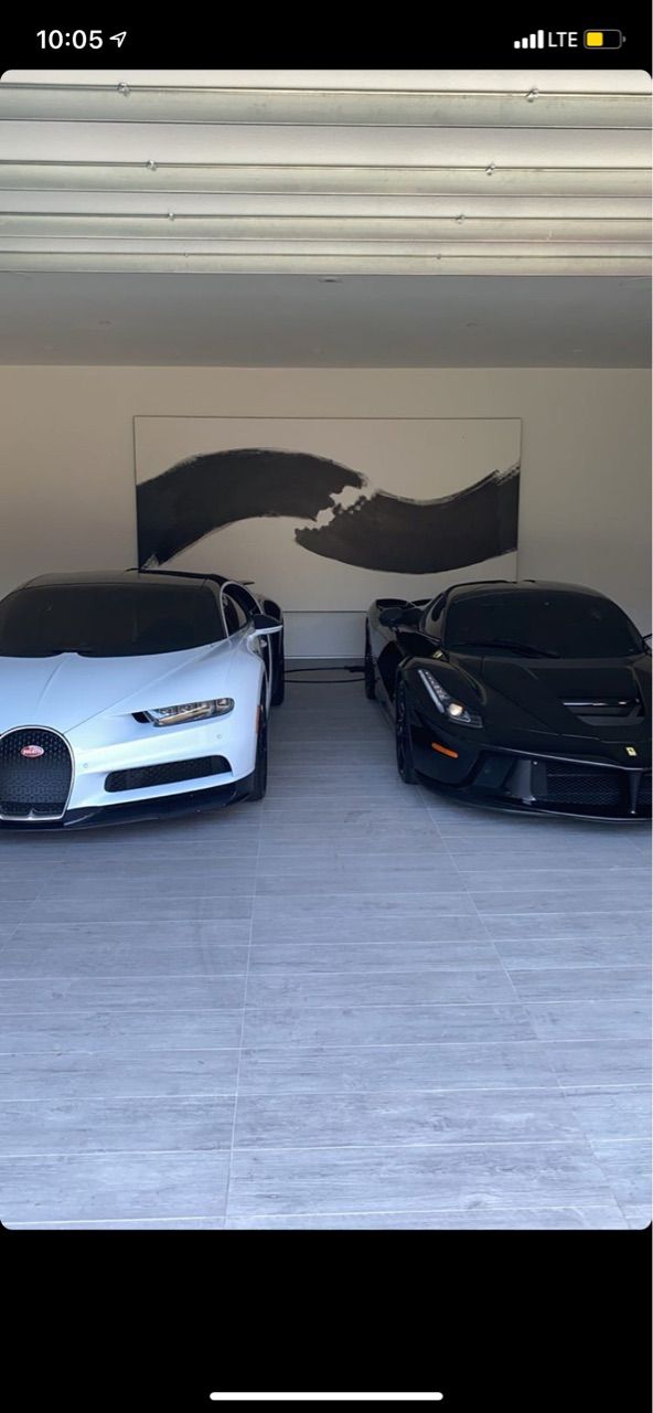 two bugatti cars parked in a garage next to each other on the floor