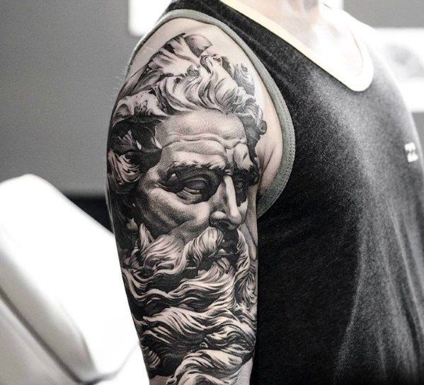 a man's arm with a black and white portrait of an ancient greek god