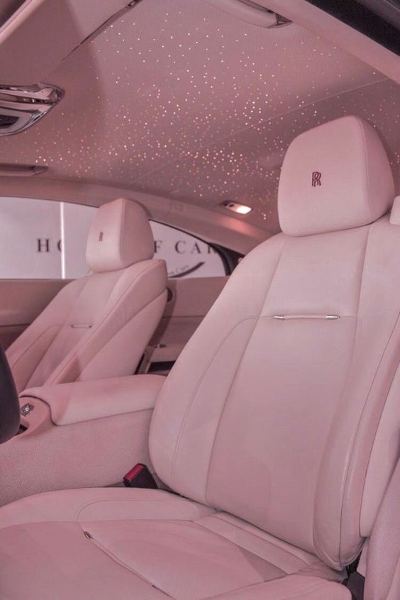 the interior of a luxury car with white leather seats and sparkling lights on the ceiling