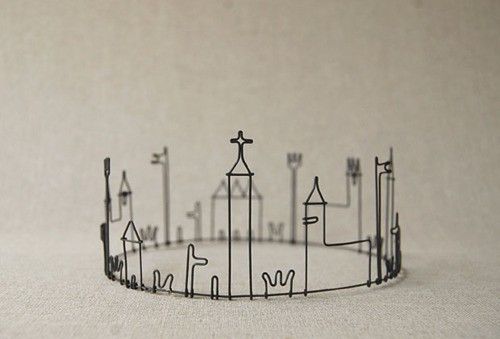 a wire sculpture of a city with tall buildings and crosses on it's sides