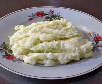 mashed potatoes on a white plate with red flowers