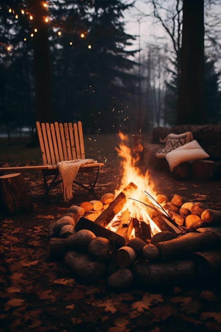 a campfire with logs and chairs around it