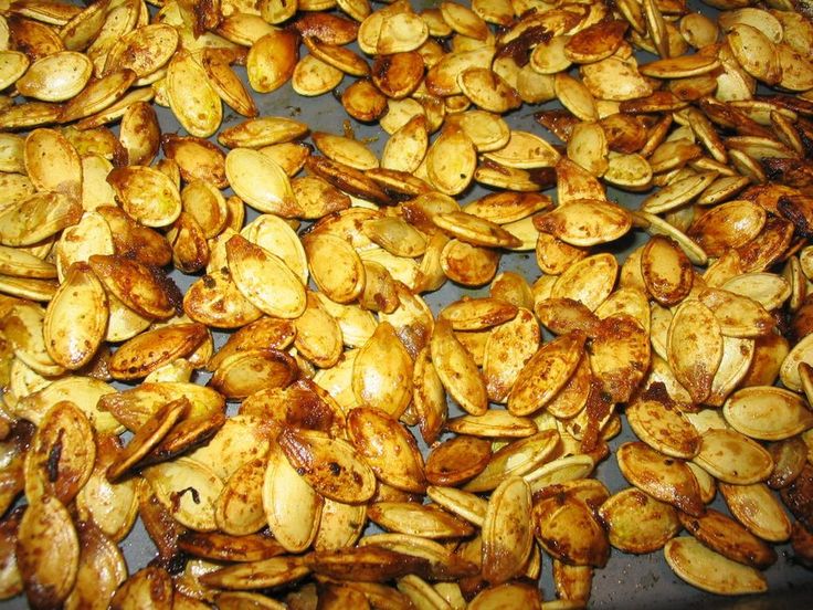 roasted pumpkin seeds on a baking sheet ready to be cooked in the oven for roasting