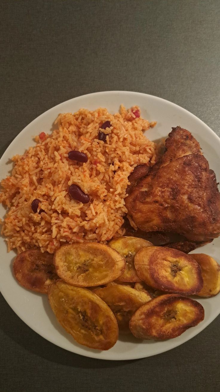 a white plate topped with meat and rice next to sliced bananas on a table top