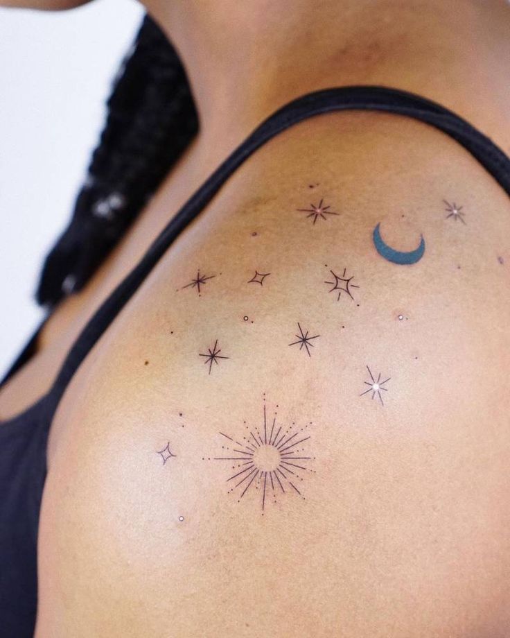 a woman with stars and a crescent tattoo on her shoulder