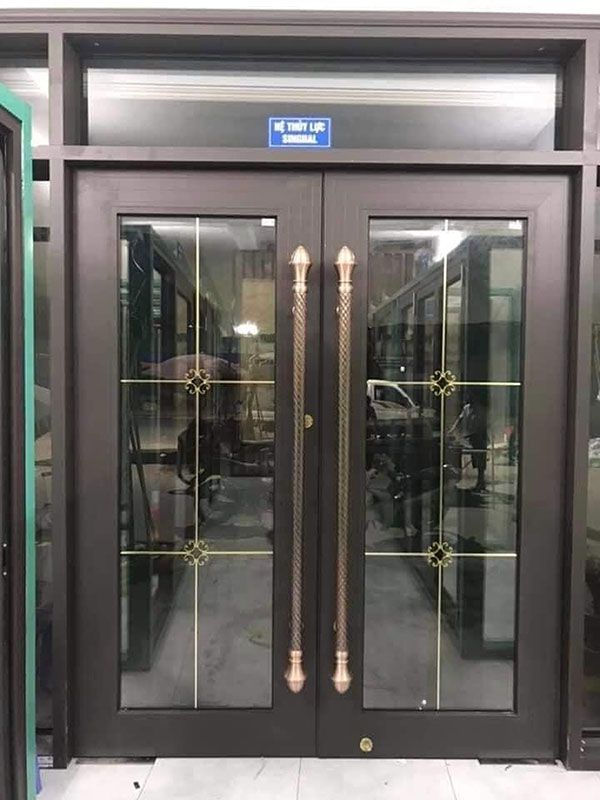 an entrance to a building with glass doors and gold trimmings on the sides