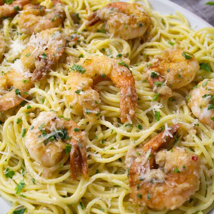 pasta with shrimp and parmesan cheese on a white plate