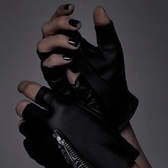 a woman's hands with black nail polish and gloves