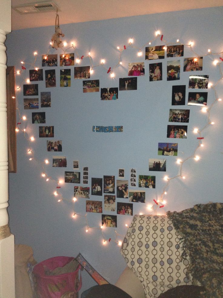 a heart shaped photo frame with lights hanging from it's sides and pictures on the wall