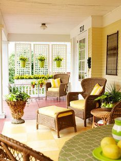 a porch with wicker furniture and potted plants