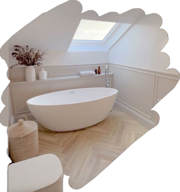 a white bath tub sitting under a window next to a toilet in a room with wooden floors