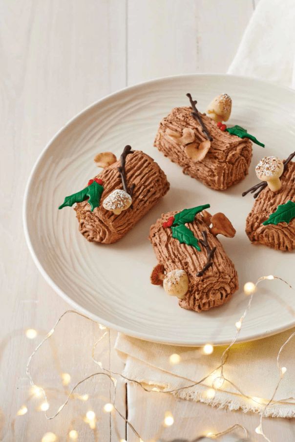 four small pieces of food on a white plate with lights in the backgroud