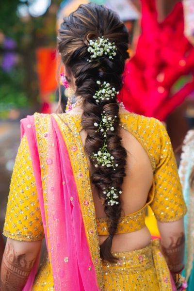 a woman with long hair wearing a yellow dress and pink sari is seen from the back