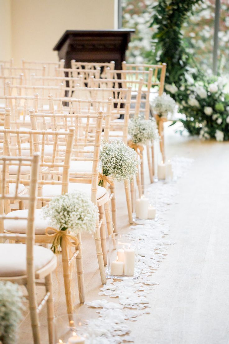 rows of chairs with flowers and candles on the floor in front of an open window