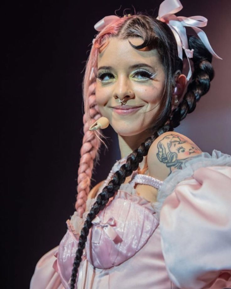 a girl with pigtails and braids on her head is smiling at the camera