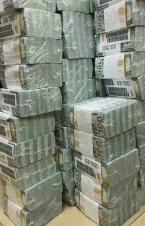 stacks of money sitting on top of each other in a store aisle next to boxes