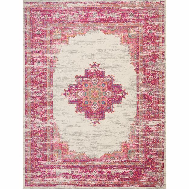 a pink and white area rug with an ornate medallion design on the center, in front of