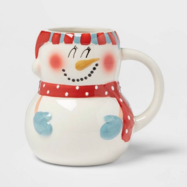 a ceramic snowman mug with a red and white scarf around it's neck