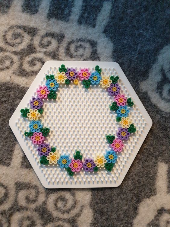 a white plate with flowers on it sitting on a carpet next to a blue rug