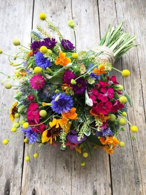 a bouquet of colorful flowers sitting on top of a wooden floor next to a string