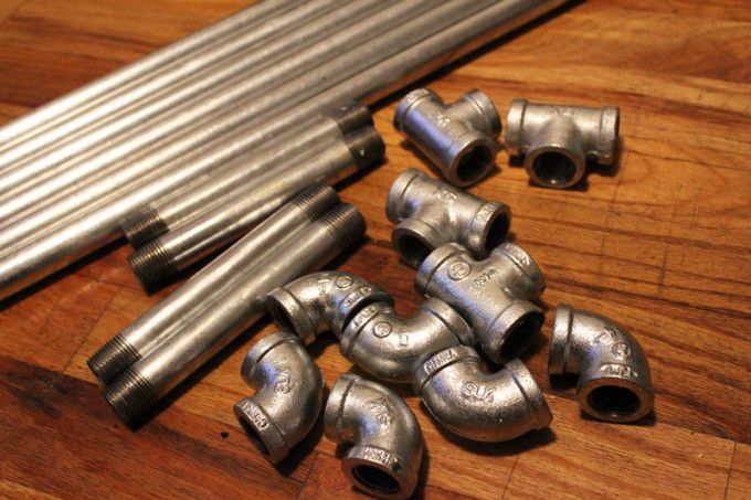 several stainless steel pipes laying on a wooden table