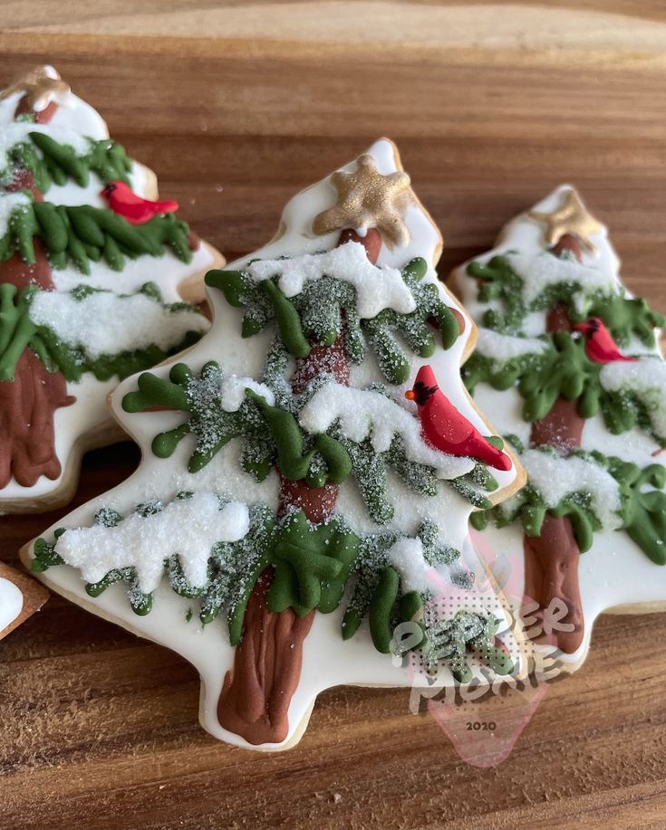 three decorated cookies sitting on top of a wooden table