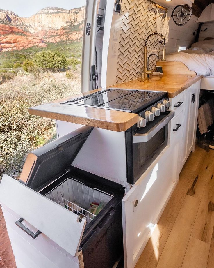 the interior of a camper with an oven and sink in it's center