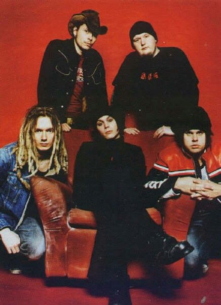 the band rascalie posing for a photo in front of a red background