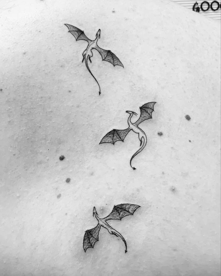 three flying bats on the back of a woman's stomach