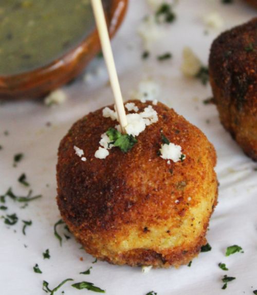 two crab cakes with toothpicks sticking out of them on a white tablecloth