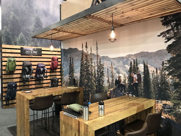 a wooden table sitting in front of a wall with mountains and trees painted on it