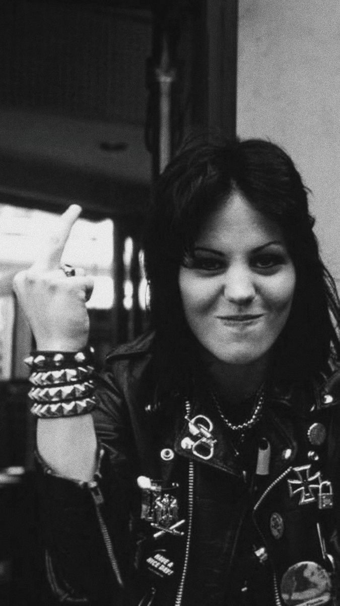 a black and white photo of a woman wearing a leather jacket