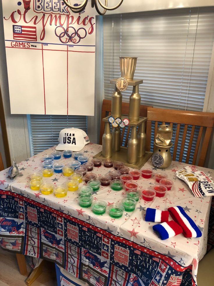 a table topped with cups and bowls filled with liquid next to a sign that says olympic