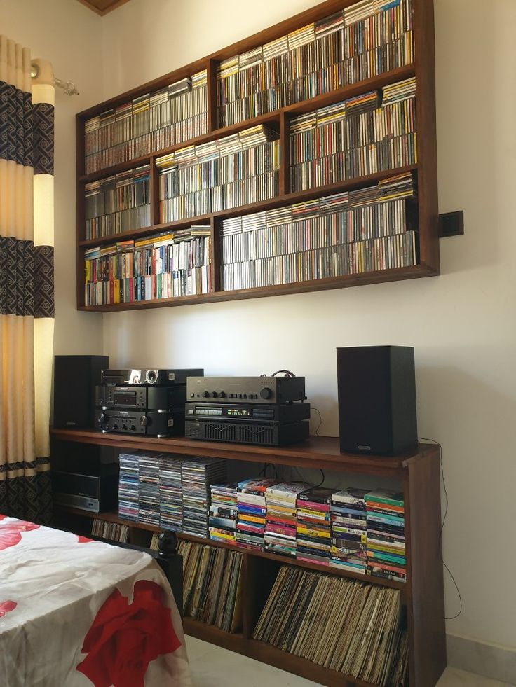 an entertainment center filled with lots of books and music cassettes on top of it