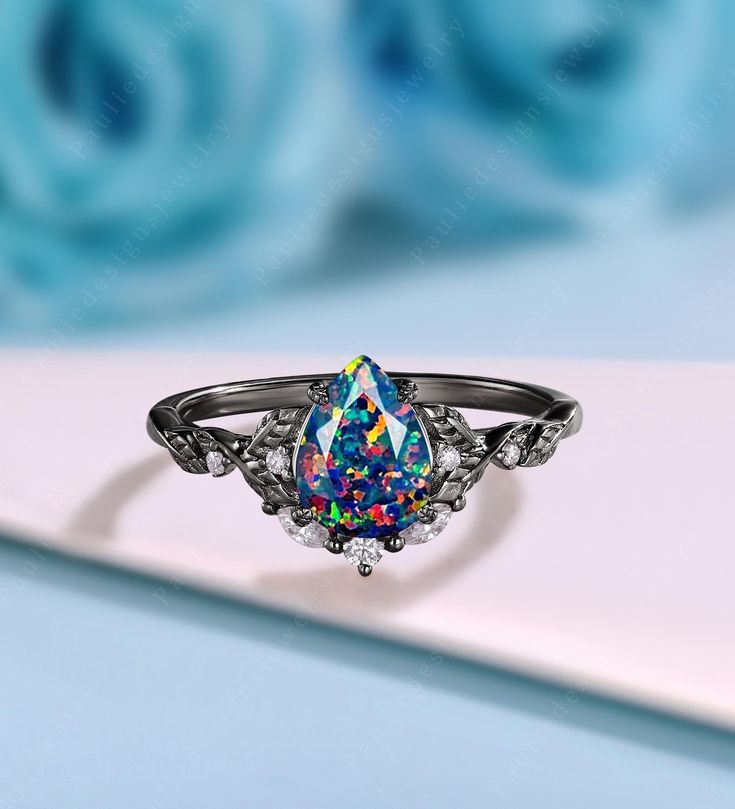 a ring with an opal colored stone in the center and diamond accents on it